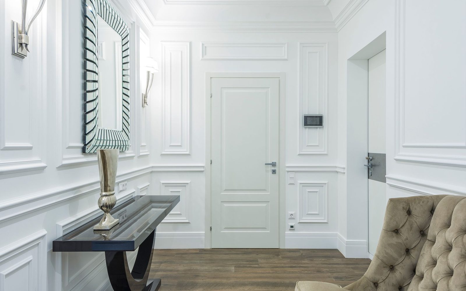 Panelled internal door with painted wall mouldings in a hallway