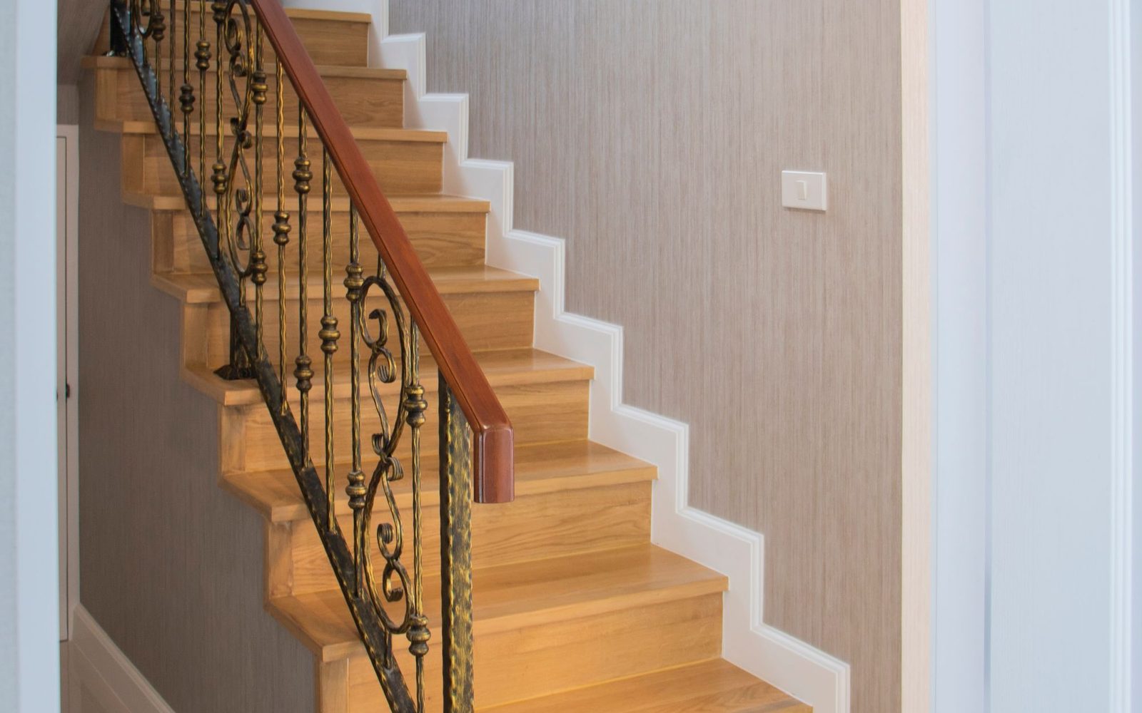 Oak staircase with a timber handrail in a house hallway